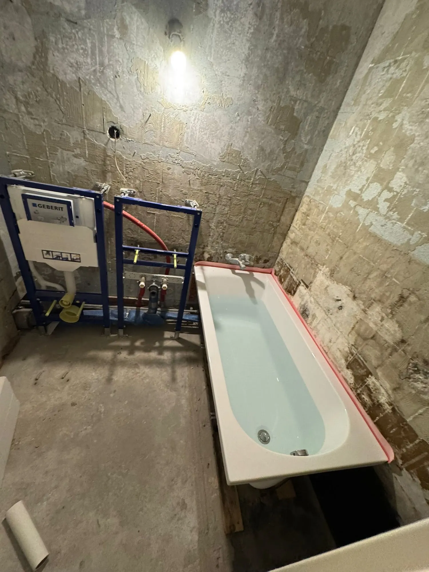 Geberit Unterputz-Spülkasten und platzierte Badewanne im Rohbauzustand